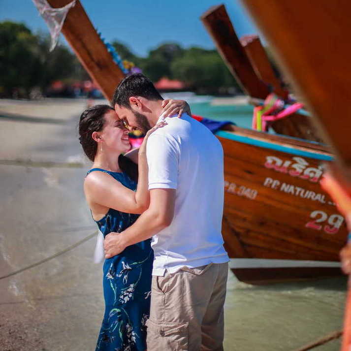 romance on the beach with longtail boat in the background by Krabi honeymoon photographer